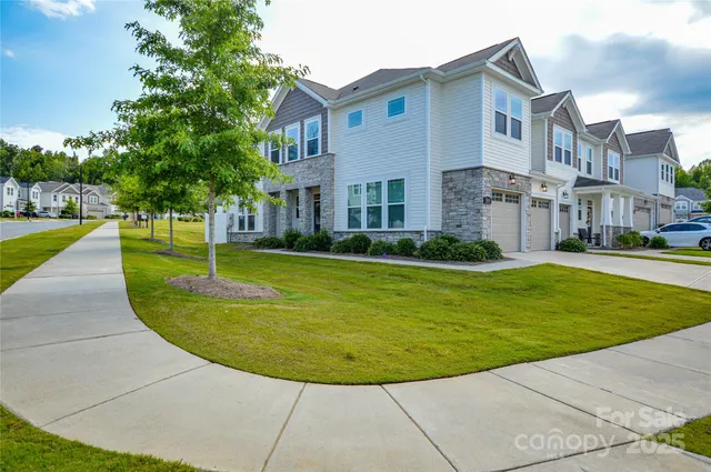 a view of a white house with a yard