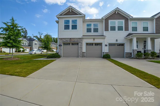 a front view of a house with a yard and trees