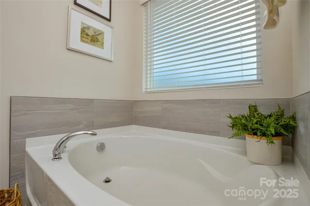 a white bath tub sitting in a bathroom next to a white cabinet