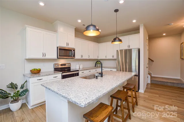 a kitchen with kitchen island a large counter space cabinets and appliances