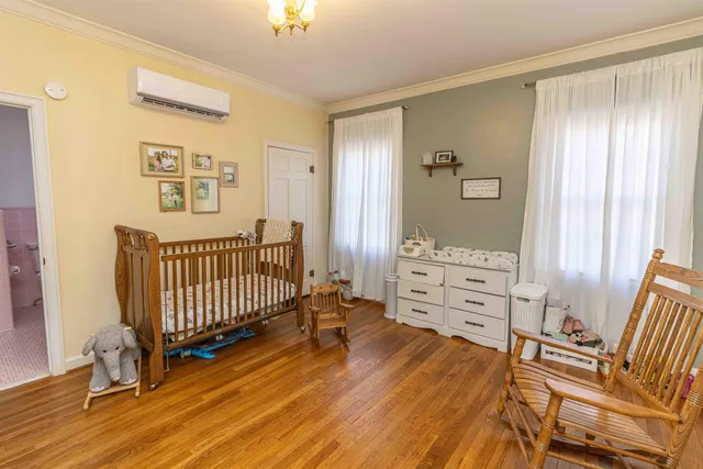a view of a bedroom with furniture and wooden floor
