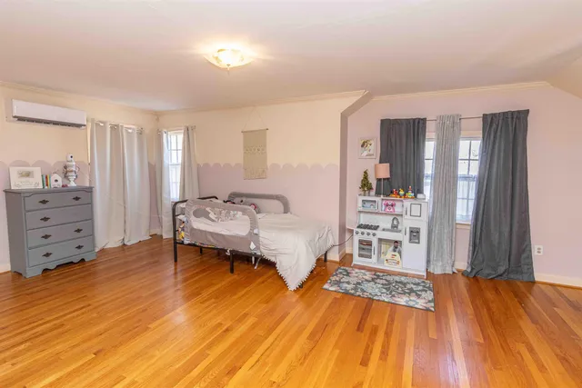 a spacious bedroom with a bed and a dresser in it
