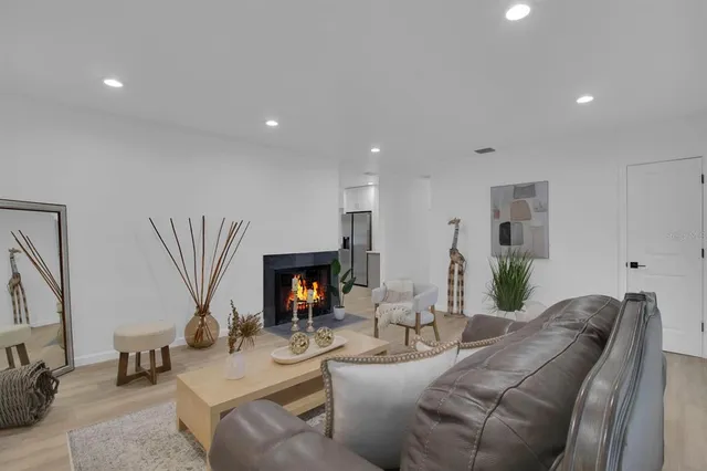 a living room with furniture a fireplace and a flat screen tv