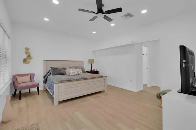 a spacious bedroom with a bed and a television