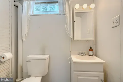 a bathroom with a toilet sink and mirror