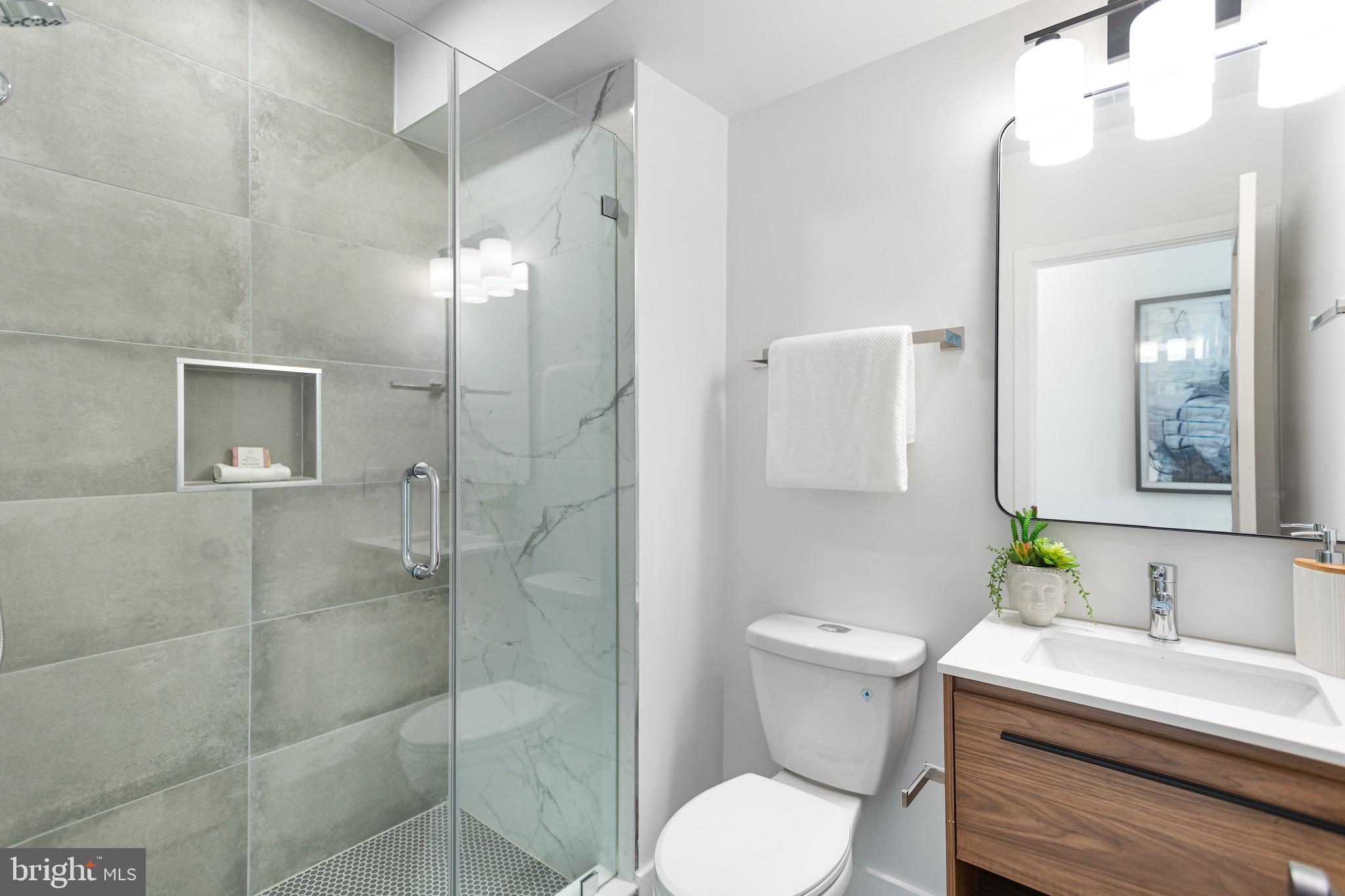 845 19th Street Northeast, Unit PH10 Washington, DC 20002 - Photo 17 of 21 a bathroom with a sink a toilet and shower