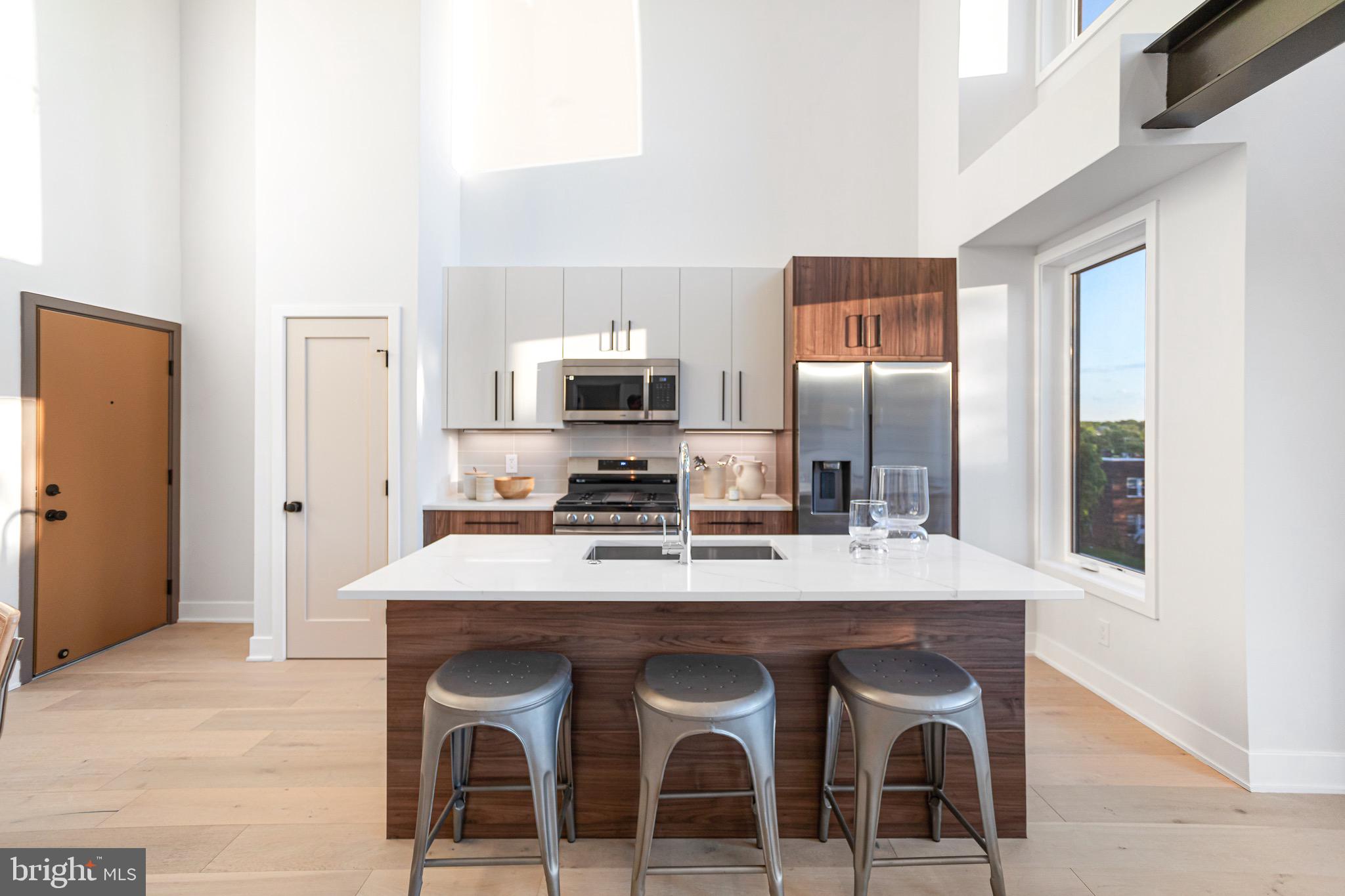 845 19th Street Northeast, Unit PH10 Washington, DC 20002 - Photo 6 of 21 a kitchen with a dining table chairs and refrigerator