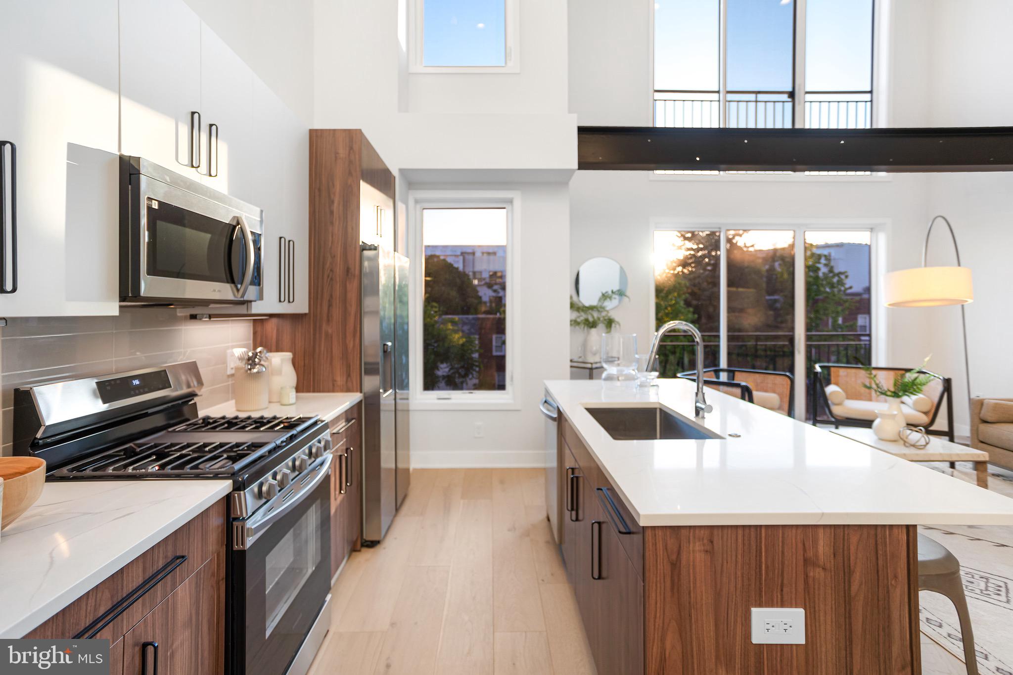 845 19th Street Northeast, Unit PH10 Washington, DC 20002 - Photo 7 of 21 a kitchen with stainless steel appliances a sink stove and microwave