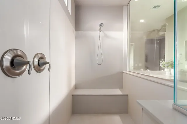 a bathroom with a shower a mirror and a shower