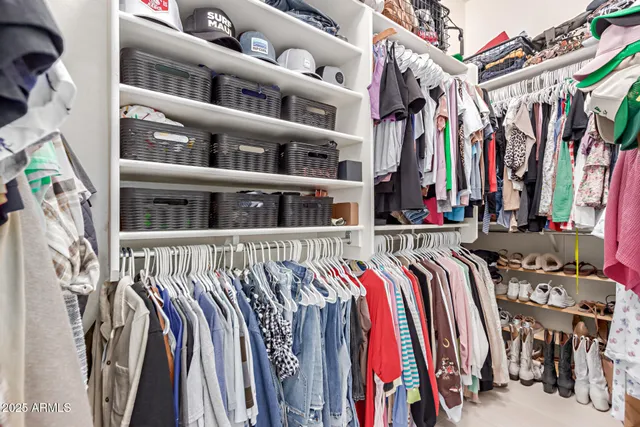 a view of walk in closet with clothes and shoes