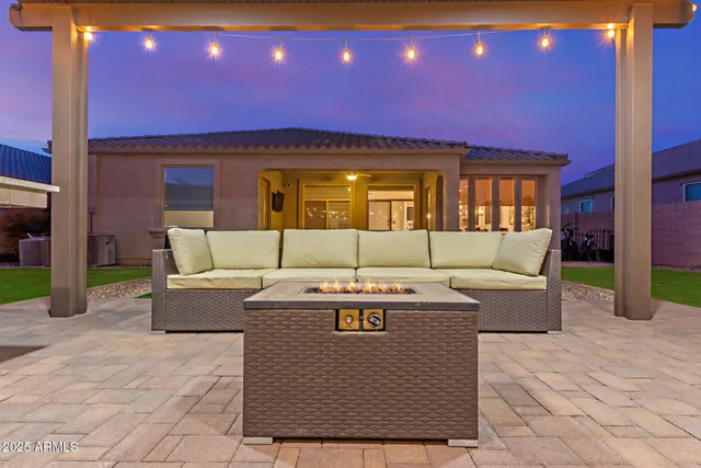 a view of a house with backyard and sitting area