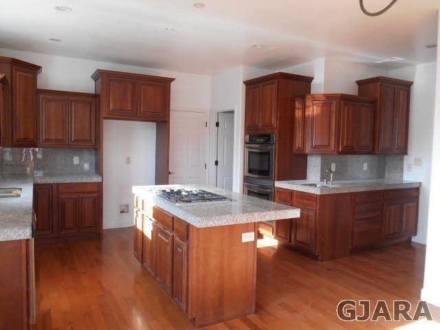 2264 L Road Grand Junction, CO 81505 - Photo 15 of 20 a kitchen with stainless steel appliances granite countertop a stove a sink dishwasher and a refrigerator with wooden cabinets