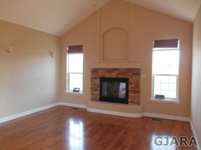 2264 L Road Grand Junction, CO 81505 - Photo 6 of 20 an empty room with wooden floor fireplace and windows