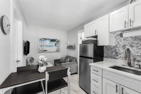 a kitchen with stainless steel appliances kitchen island granite countertop a sink stove and refrigerator