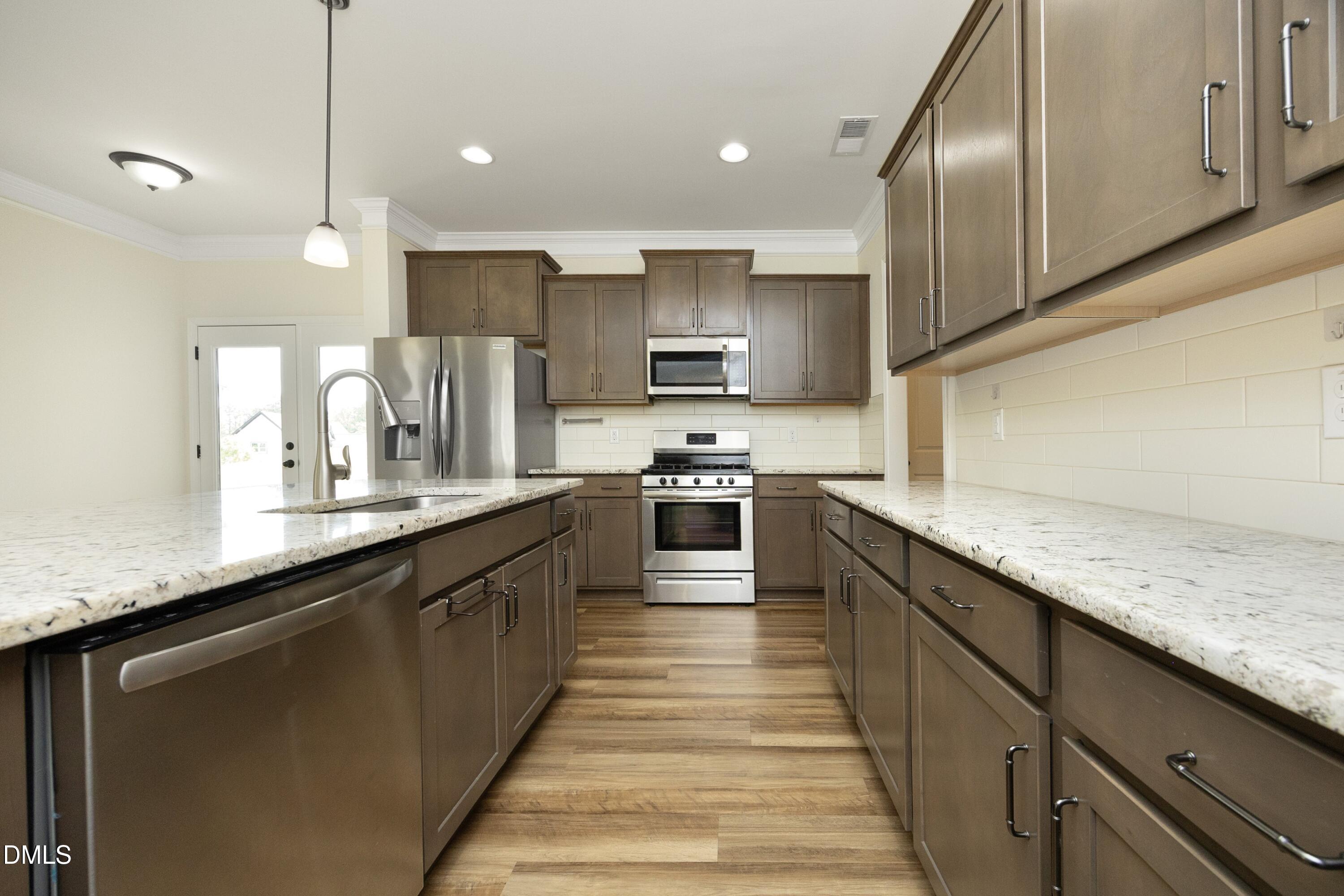 824 Country Downs Road Wake Forest, NC 27587 - Photo 16 of 41 a large kitchen with stainless steel appliances kitchen island granite countertop a sink counter space a stove and a granite counter top