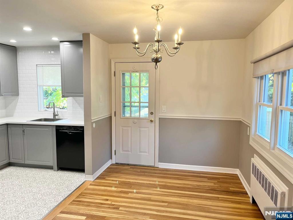 678 Grove Street Ridgewood, NJ 07450 - Photo 2 of 14 a view of a hallway with wooden floor and a chandelier