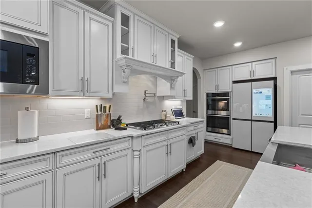 a kitchen with stainless steel appliances white cabinets and a refrigerator