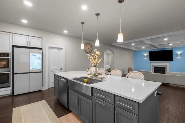 a kitchen with stainless steel appliances granite countertop a sink a refrigerator and a stove