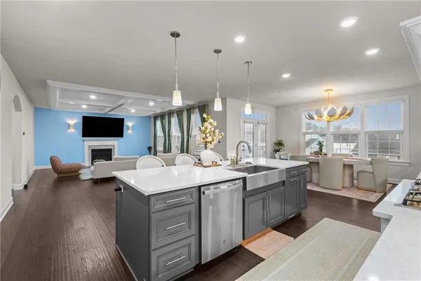 a open kitchen with stainless steel appliances granite countertop a sink dishwasher a stove and a refrigerator with wooden floor