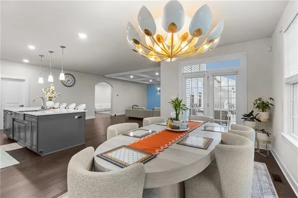 a living room with furniture a chandelier and a dining room