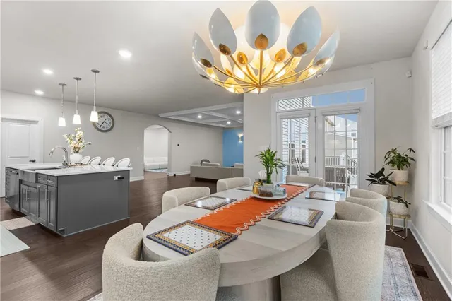 a living room with furniture a chandelier and a dining room
