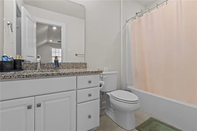 a bathroom with a granite countertop sink toilet and mirror