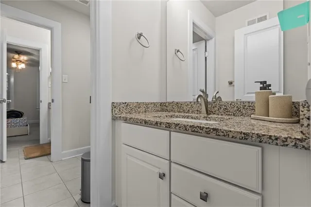 a bathroom with a granite countertop sink and a mirror