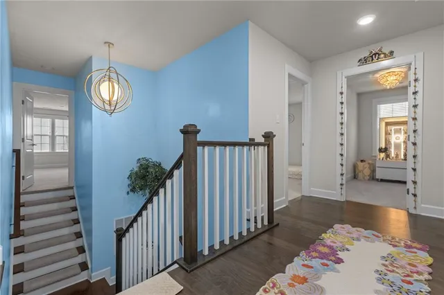 a hallway with wooden floor windows and a chandelier