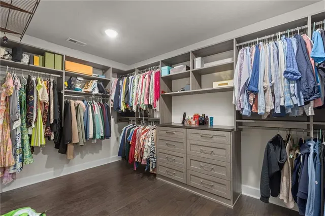 a view of walk in closet with clothes and shoes
