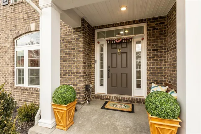 a view of a door with a bench and potted plants