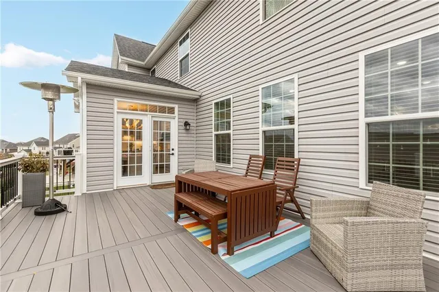 a view of a deck with table and chairs with wooden floor and floor to ceiling window