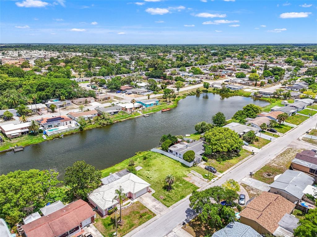 7211 Ashwood Drive Port Richey, FL 34668 - Photo 2 of 12 an aerial view of residential houses with outdoor space and lake view