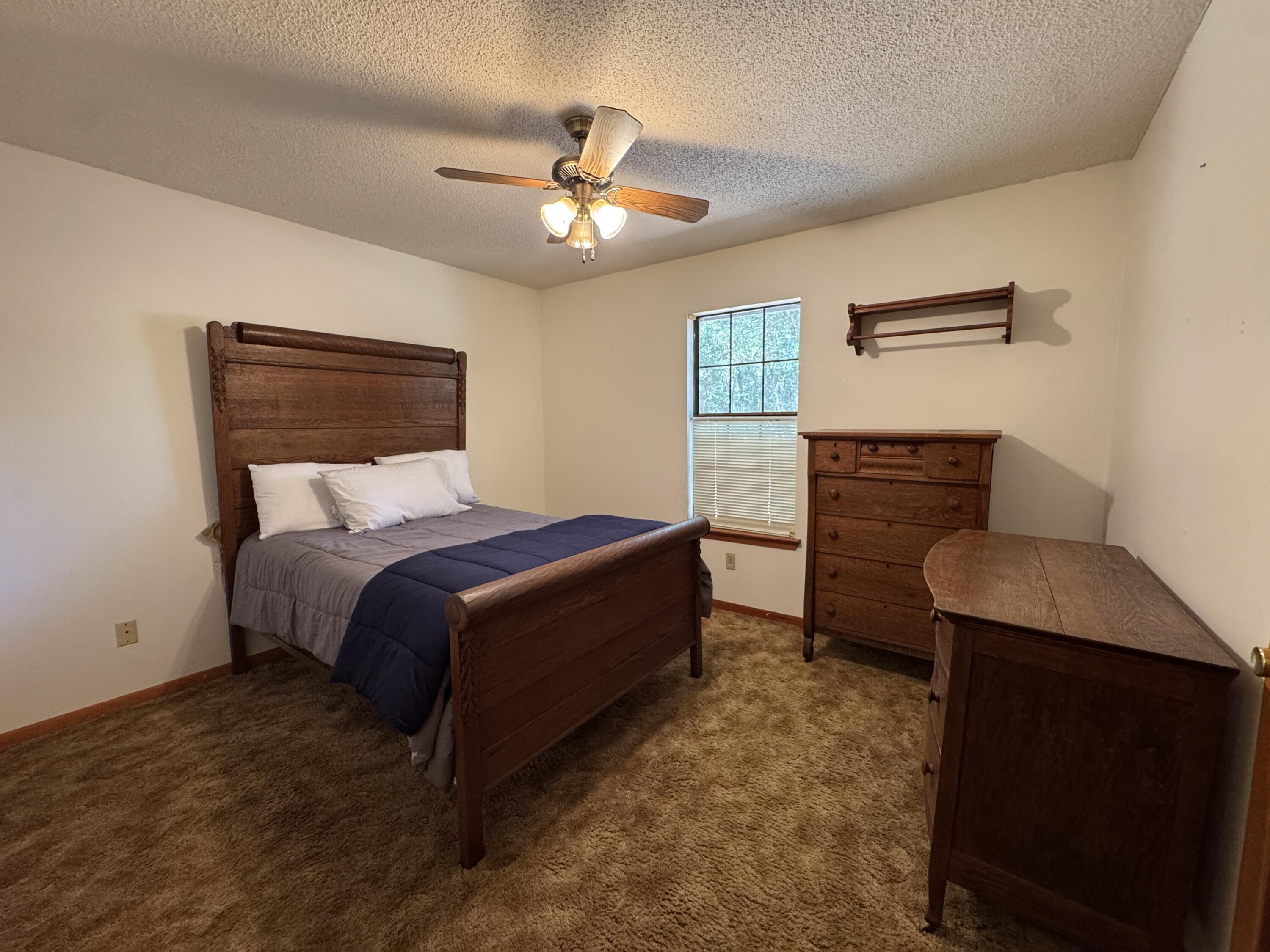 2928 Aplin Road Crestview, FL 32539 - Photo 18 of 42 a bed room with a bed and a chandelier