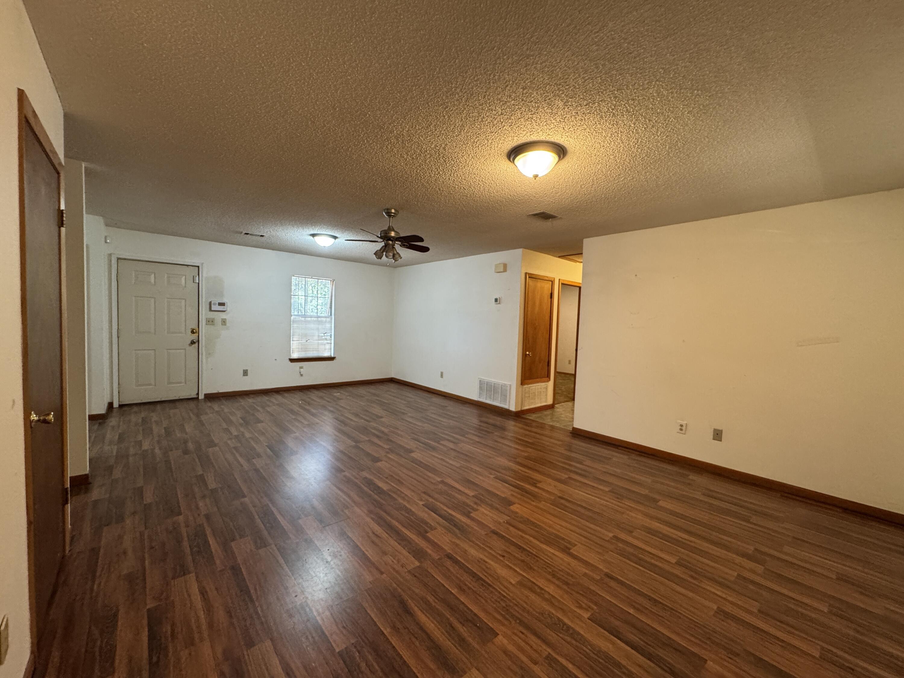 2928 Aplin Road Crestview, FL 32539 - Photo 4 of 42 an empty room with wooden floor and windows