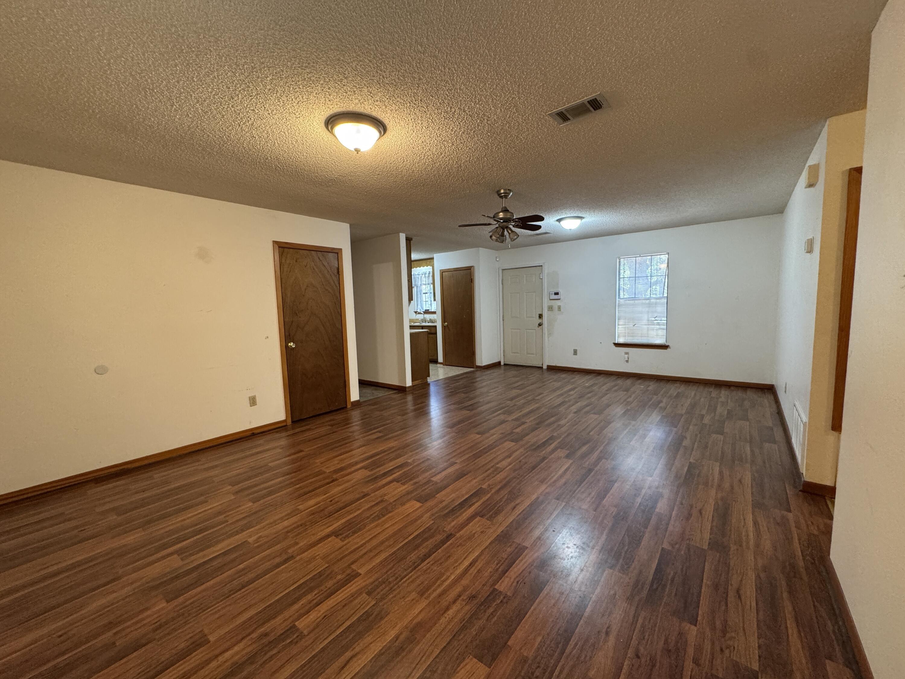 2928 Aplin Road Crestview, FL 32539 - Photo 5 of 42 a view of an empty room with wooden floor and a window