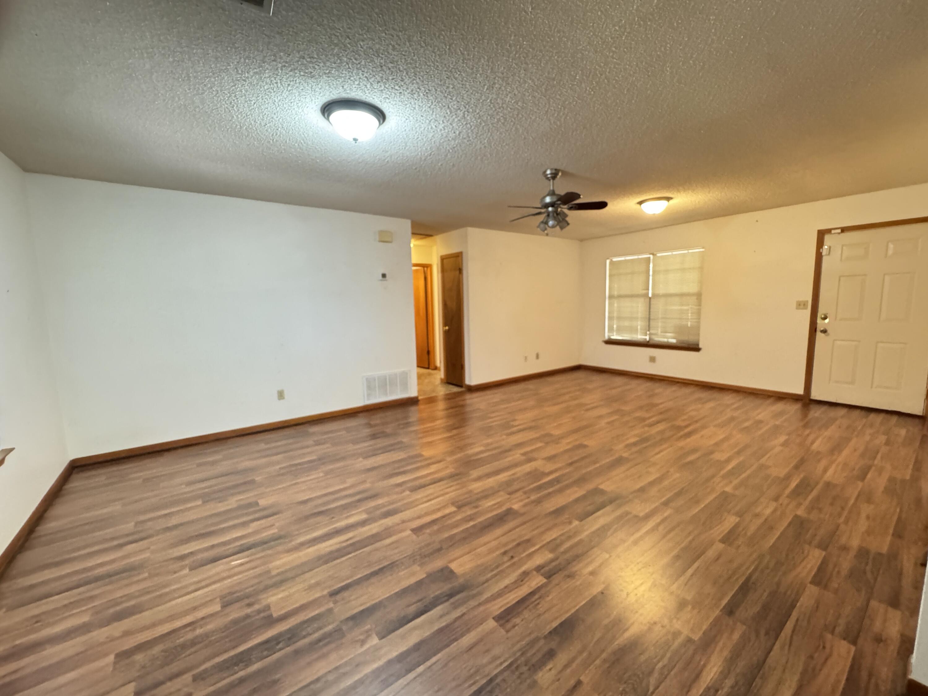 2928 Aplin Road Crestview, FL 32539 - Photo 6 of 42 an empty room with wooden floor and windows
