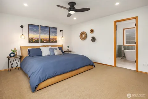 a bedroom with a large bed and a chandelier