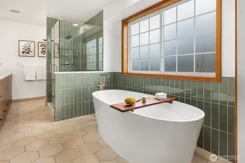 a white bath tub sitting in a bathroom next to a window