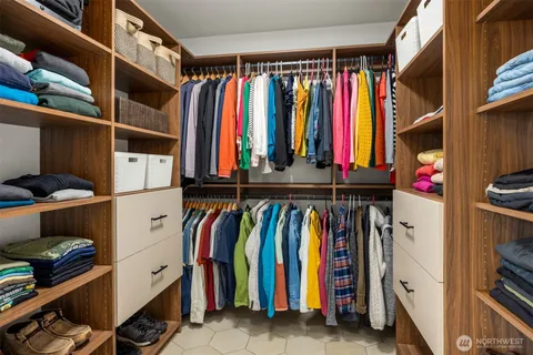 a view of walk in closet with clothes and shoes