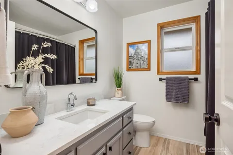 a bathroom with a granite countertop sink mirror vanity and toilet