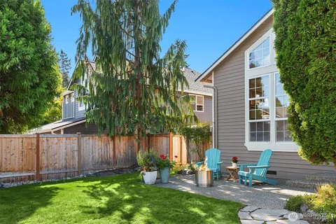 a backyard of a house with table and chairs a barbeque with a table and chairs