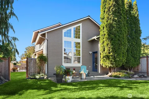 a front view of house with a yard and potted plants