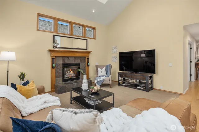 a living room with furniture a flat screen tv and a fireplace