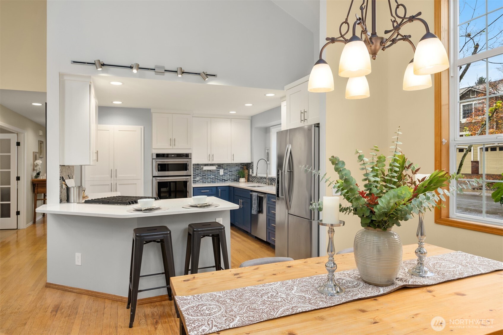2714 182nd Place Southeast Bothell, WA 98012 - Photo 8 of 36 a kitchen with stainless steel appliances kitchen island granite countertop a table chairs in it and wooden floors