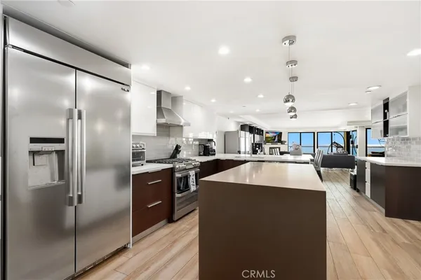 a large kitchen with stainless steel appliances granite countertop a lot of counter space and wooden floor