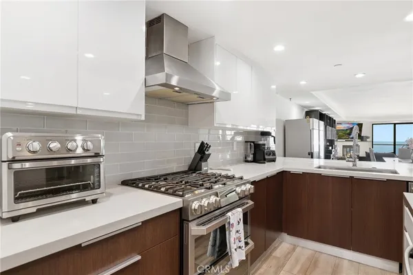 a kitchen with stainless steel appliances granite countertop a sink a stove and a refrigerator