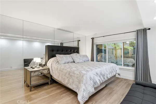 a bedroom with a bed a mirror and a desk