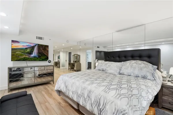 a living room with couches and kitchen view with wooden floor