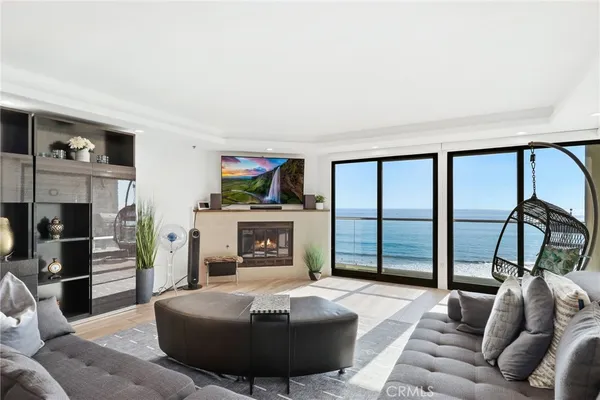 a living room with furniture a floor to ceiling window and a flat screen tv