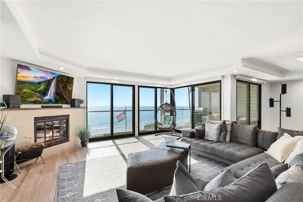 a living room with furniture a flat screen tv and a floor to ceiling window